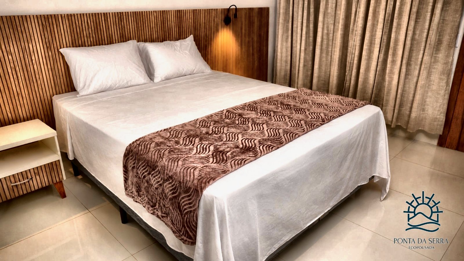 Apartamento com cama de casal ampla e iluminação de leitura